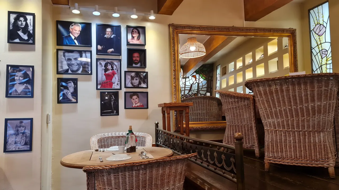 Retratos a preto e branco e a cores de figuras italianas, cadeirões de verga e um espelho dourado